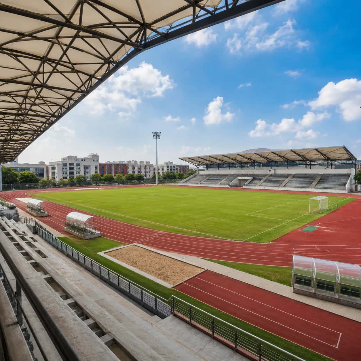 Outdoor stadium with a running track, field, and tensile roof grandstand