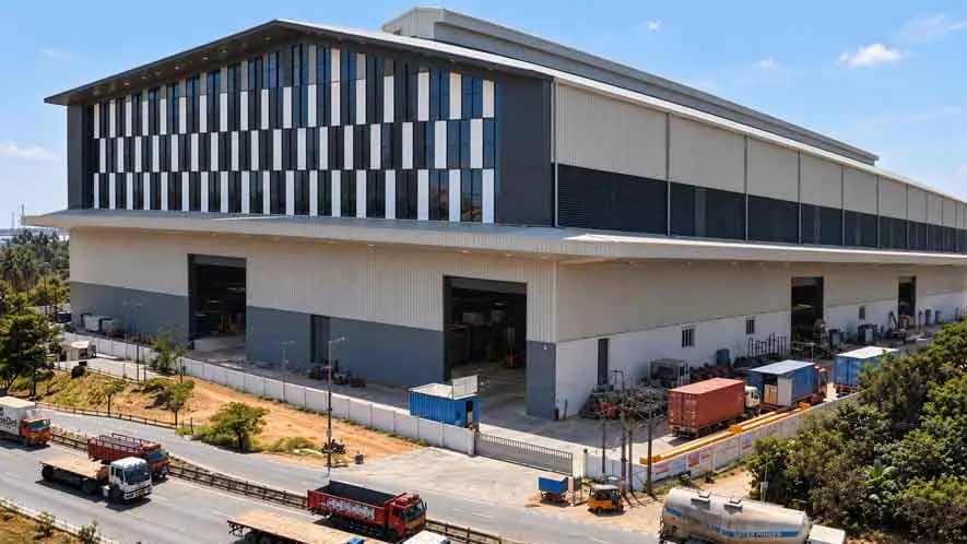 Grey and white industrial warehouse with a checkered upper facade